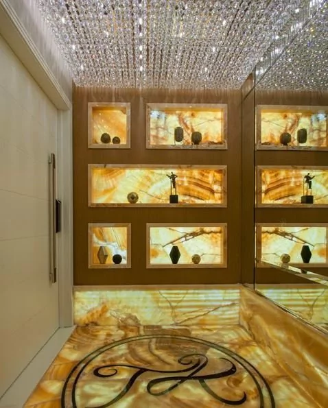 Lustre plafon de cristal em hall de entrada luxuoso com iluminação elegante e prateleiras iluminadas. Lustres Gênesis loja online de Lustres e Iluminação Decorativa