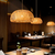 Pendente Artesanal Sumatra iluminando um ambiente elegante com mesas de madeira. Lustres Gênesis Site online venda de Lustres e Iluminação Decorativa