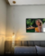 Pendente de Cristal Parma iluminando um quarto com decoração moderna, ao lado de um quadro na parede.