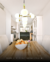 Luminária de teto pendente moderno com 14 globos leitosos no design Cacho Jabuticaba, instalada em uma sala de jantar iluminada. Lustres Gênesis loja online de Lustres e Iluminação Decorativa