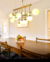 Luminária de teto pendente moderno com 14 globos leitosos em uma sala de jantar elegante. Lustres Gênesis loja online de Lustres e Iluminação Decorativa