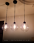 Lustre pendente Sarvah com cúpulas de vidro transparente iluminando a mesa de jantar. Lustres Gêneis loja online de Lustres e Iluminação Decorativa