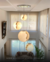 Lustre pendente grande com 3 esferas de mármore suspensas em uma sala com pé direito duplo. Lustres Gênesis Site online venda de Lustres e Iluminação