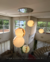 Lustre pendente grande com três esferas de mármore suspensas em sala com pé direito duplo. Lustres Gênesis Site online venda de Lustres e Iluminação