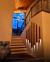 Lustre pendente Sarvah com 12 globos âmbar em escada de casa com pé direito alto Lustres Gênesis loja online de Lustres e Iluminação Decorativa