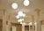 Luminária de teto pendente em formato de esfera branca instalada em sala com pé direito alto. Lustres Gênesis loja online de Lustres e Iluminação Decorativa