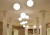 Luminária de teto pendente em formato de esfera branca instalada em sala com pé direito alto. Lustres Gênesis loja online de Lustres e Iluminação Decorativa