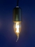 Lâmpada de Filamento de Led Vela Chama 2W acesa, com design de gaiola de esquilo, pendurada em um fundo azul. Lustres Gênesis loja online de Lustres e Iluminação Decorativa