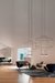 Luminária de teto pendente moderno Domus em uma sala de estar com cadeiras modernas e piso de madeira. Lustres Gênesis loja online de Lustres e Iluminação Decorativa