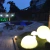 Luminária de Chão Meia Esfera Soleil Branca iluminando área externa ao lado de piscina. Lustres Gênesis loja online de Lustres e Iluminação Decorativa
