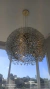 Lustre pendente de cristal Ninho Cúpula instalado em um ambiente com janelas amplas ao fundo. Lustres Gênesis loja online de Lustres e Iluminação Decorativa