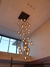 Lustre Pendente Sarvah com 36 globos conhaque espelhados em uma sala com pé direito duplo. Lustres Gênesis loja online venda de Lustres e Iluminação