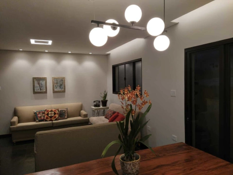 Pendente Moderno Oriana com 5 globos iluminando uma sala de estar elegante. Lustres Gênesis loja online de Lustres e Iluminação Decorativa