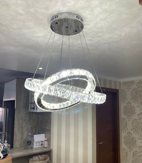 Lustre pendente de cristal com design de aliança dupla em ambiente interno. Lustres Gênesis loja online de Lustres e Iluminação Decorativa