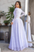 Vestido longo branco rendado com manga longa, modelo Joana, apresentado em um ambiente moderno.