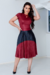 Vestido midi plissado em cirrê nas cores vermelho e preto, com manga curta e decote discreto, usado por uma modelo em um ambiente interno.