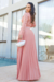 Vestido longo plissado em crepe com renda nas mangas, na cor rosê , exibido por uma modelo em um ambiente elegante.