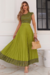 Modelo vestindo um conjunto verde com cropet e saia plissada, destacando detalhes da saia na malha Flower.