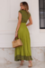 Modelo vestindo um conjunto verde com cropet e saia plissada, destacando detalhes da saia na malha Flower.