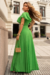 Modelo vestindo um conjunto de blusa e saia longa plissada na cor verde lima, com detalhes em malha lurex.