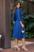 Vestido midi azul com mangas 3/4 e detalhe em malha lese, usado por uma modelo em ambiente externo.