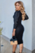 Vestido tubinho preto com textura em malha e elastano, apresentando mangas bufantes e zíper nas costas, modelado por uma mulher em um ambiente moderno.