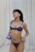 Bikini Duetto Polka Dots Cielo de Kinita, modelo usando corpiño doble superpuesto marrón con lunares celestes y bombacha haciendo juego, con breteles regulables y detalles de tiras para atar.