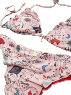 Biquíni feminino rosa com estampa colorida de desenhos variados, incluindo mãos e símbolos místicos.
