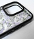 Funda para iPhone 15 Pro Max con diseño floral en tonos lilas sobre fondo transparente.