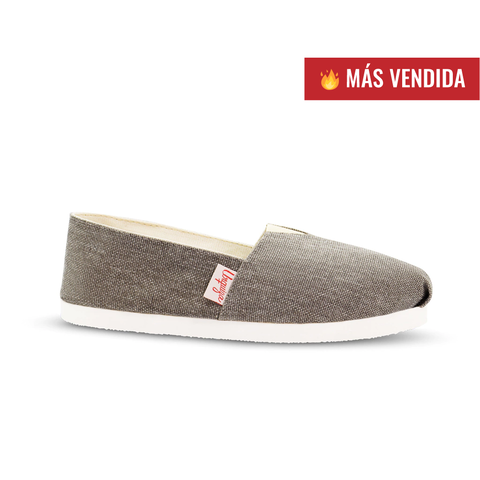 Alpargatas Arena en color gris, con suela blanca y etiqueta roja, destacando como más vendida.