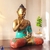 Escultura de Buda em posição de meditação, com detalhes em cores vibrantes, ideal para decoração.