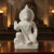 Estátua branca de Hanuman em marmorite, com detalhes esculpidos, mostrando Hanuman em posição ajoelhada com uma mão levantada e outra apoiada no joelho, sobre uma base retangular