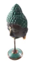 Cabeça de Buda decorativa em escultura, com detalhes em verde e bronze.