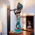 Escultura de Krishna em pose tocando flauta, com detalhes em bronze e azul, ideal para decoração de ambientes.