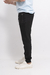 Pantalones de jogging negros con cierres laterales, vistos de perfil.