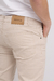 Pantalón regular color beige visto desde el lado, con etiqueta de la marca Tribu de Jah en la parte trasera.