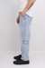 Jean cargo de color celeste con bolsillos laterales, visto de perfil. El modelo lleva una camiseta blanca y zapatillas negras.