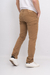 Pantalón regular color camel visto desde atrás, combinado con zapatillas blancas.