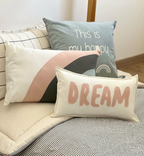  Almohadón DREAM con letras rosas aplicadas.