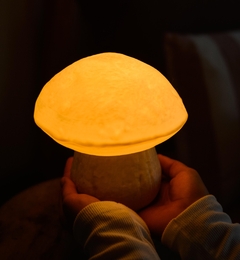 Velador honguito encendido en ambiente cálido, ideal para habitaciones infantiles.