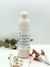 Botella de leche limpiadora facial de Sweet Spa, con fondo neutro y flores secas alrededor.