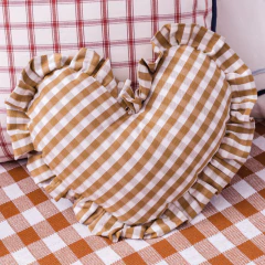 Almofada em formato de coração com estampa vichy vermelha e babados, ideal para decoração de quartos infantis ou enxoval de bebê.