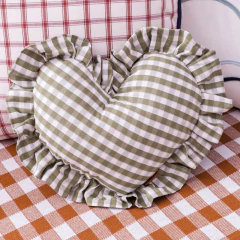 Almofada em formato de coração com estampa vichy vermelha e babados, ideal para decoração de quartos infantis ou enxoval de bebê.