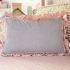 Almofada retangular com estampa vichy preta e branca, babado listrado rosa e detalhes em sianinha, ideal para decoração de quarto infantil.
