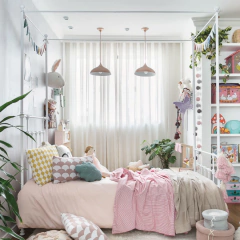 Cama de ferro solteiro estilo Versailles com dossel branca em quarto decorado infantil, com almofadas coloridas, decoração delicada e prateleiras ao fundo.