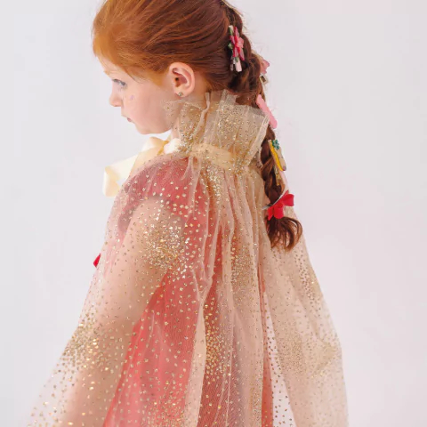 Criança vestindo a Capa Tule Esplendor Ouro da Minibossa, com tule dourado e detalhes brilhantes, ideal para fantasias de carnaval ou festas temáticas.