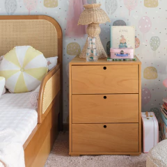 Gaveteiro Woody Cupuaçu com 3 gavetas em madeira Tauari, posicionado em um quarto decorado ao lado de uma cama.