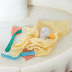 Naninha de algodão natural em formato de pato com tecido amarelo e detalhes coloridos, ideal para bebês.