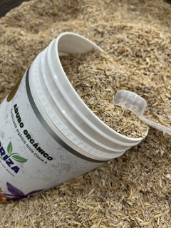 Pote de adubo orgânico para orquídeas e plantas, com dosador, mostrando o conteúdo dentro do pote e um fundo de Adubo Fortirriza.
