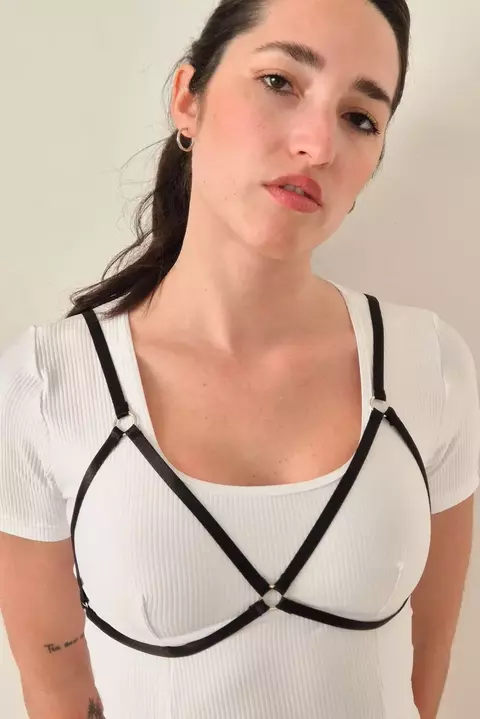 Primer plano de mujer con arnés negro Fiamma sobre una camiseta blanca de manga corta